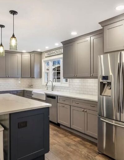 Modern kitchen with gray cabinetry, stainless steel appliances, and a central island with seating.